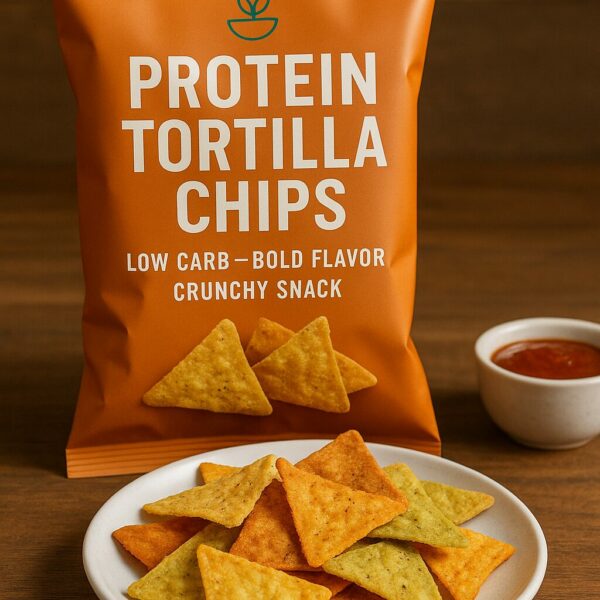 A matte orange bag labeled 'Protein Tortilla Chips' beside a white plate of multicolored triangle chips and a bowl of dipping sauce on a wooden table