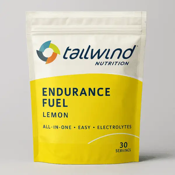 A digital product photo showcases Tailwind Nutrition Endurance Fuel Lemon flavor in a 30-serving resealable bag with a yellow and off-white design, highlighting key benefits like all-in-one fuel and electrolytes.